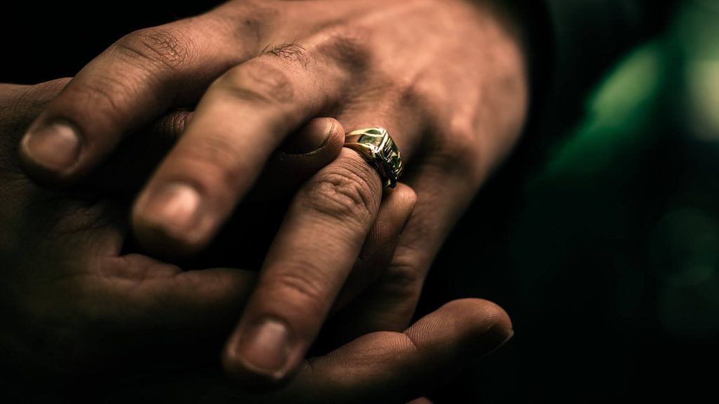 Primo piano della mano di un uomo con un anello elegante che completa il suo aspetto generale.